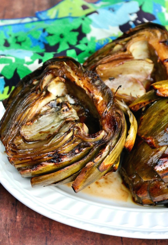 Cooked artichokes on a white platter