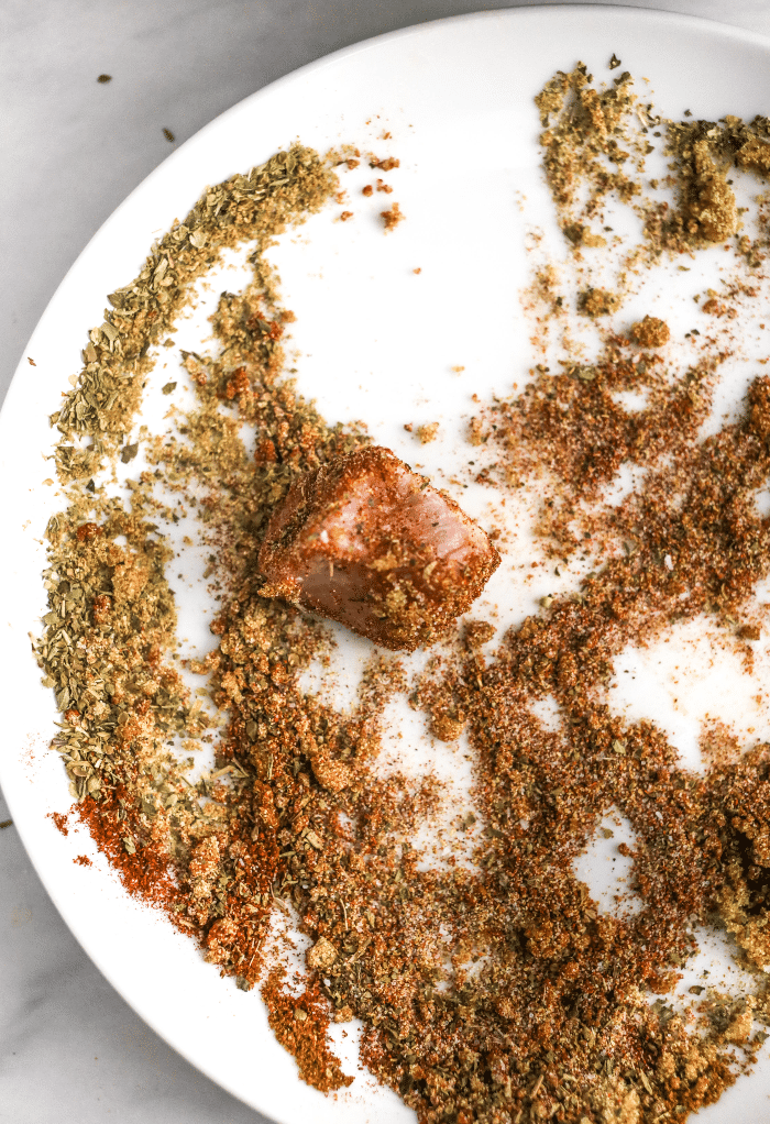 Pieces of pork rolled into spices before cooking in an Instant Pot. 