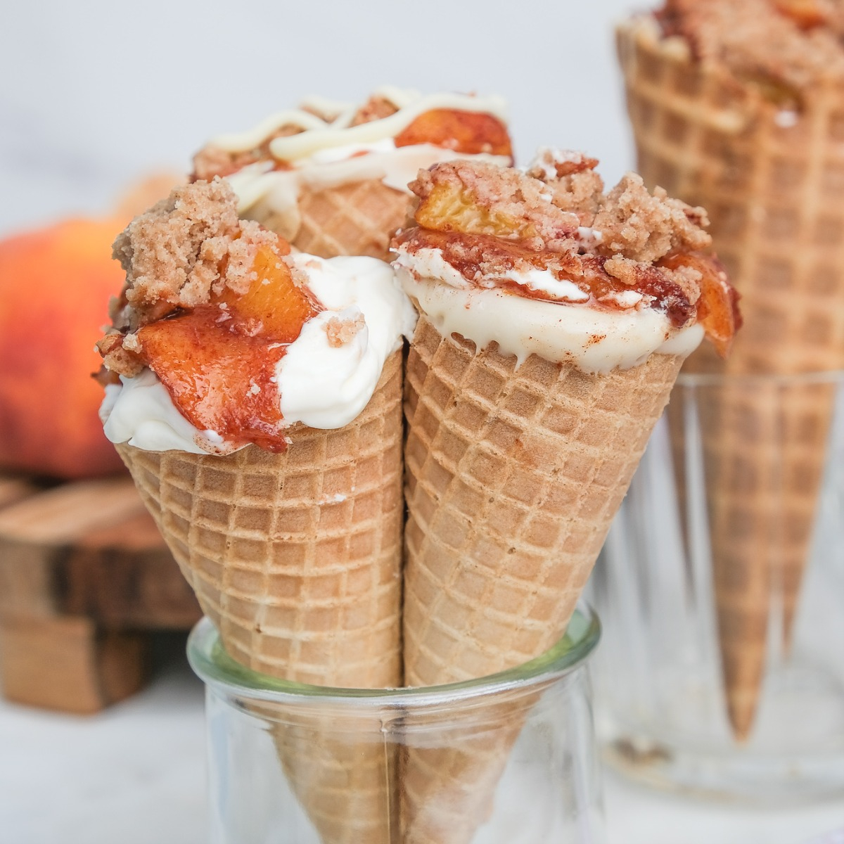 https://www.thefoodieaffair.com/wp-content/uploads/2022/08/Peach-Cobbler-Cheesecake-Cones-12002.jpg