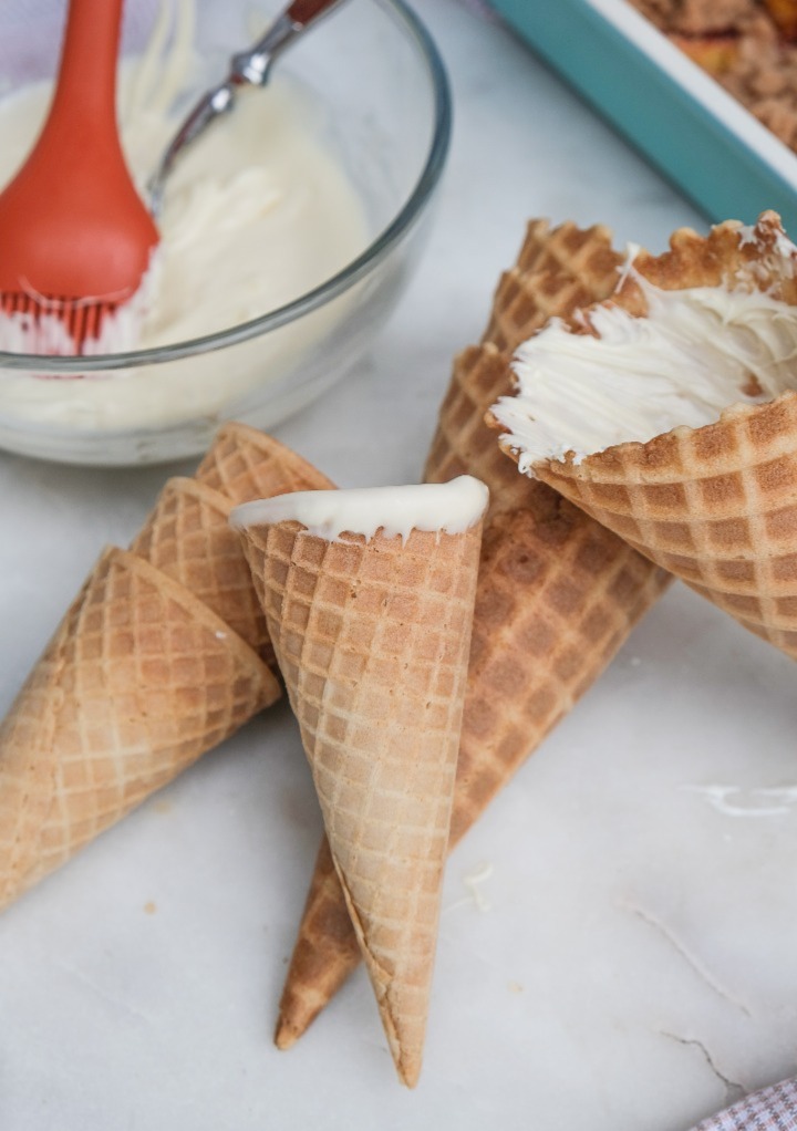 Waffle cones with melted white chocolate chips spread in the center of the waffle cones. 