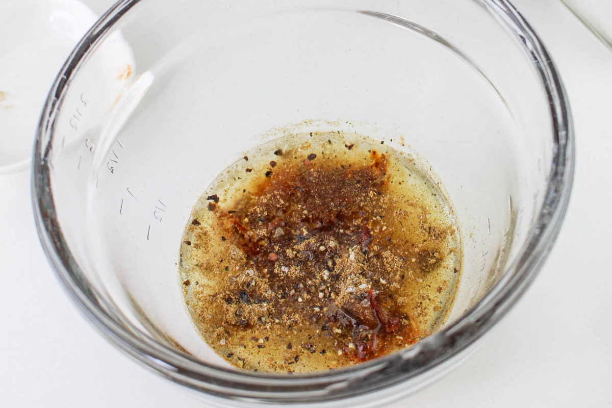 Homemade salad dressing in a clear small mixing bowl. 