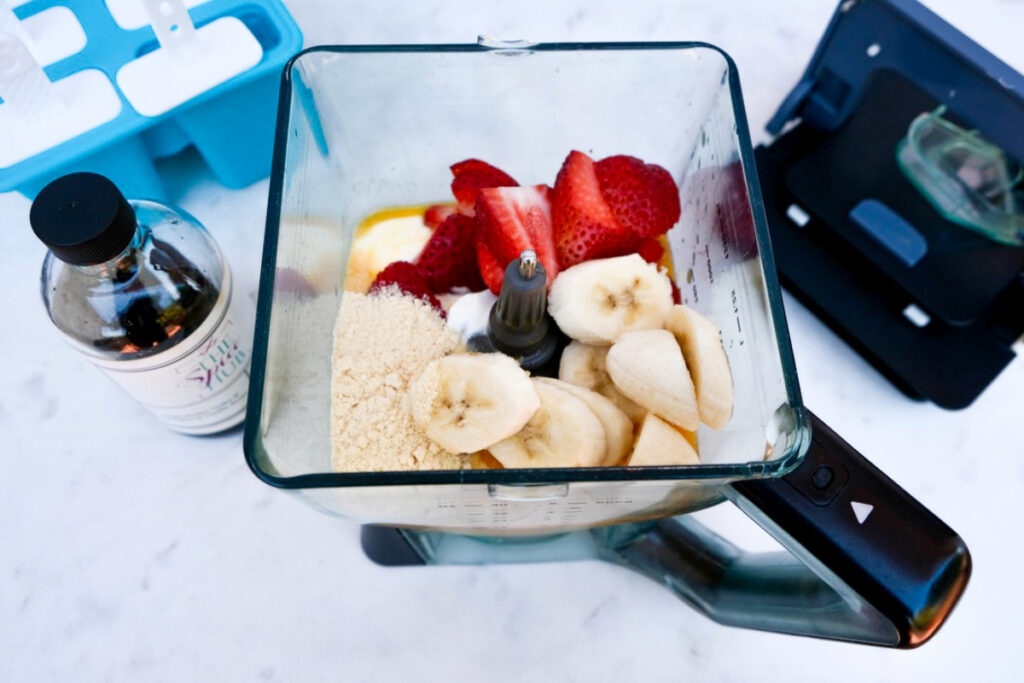 Sliced strawberries and banana in a blender ready to pulse.