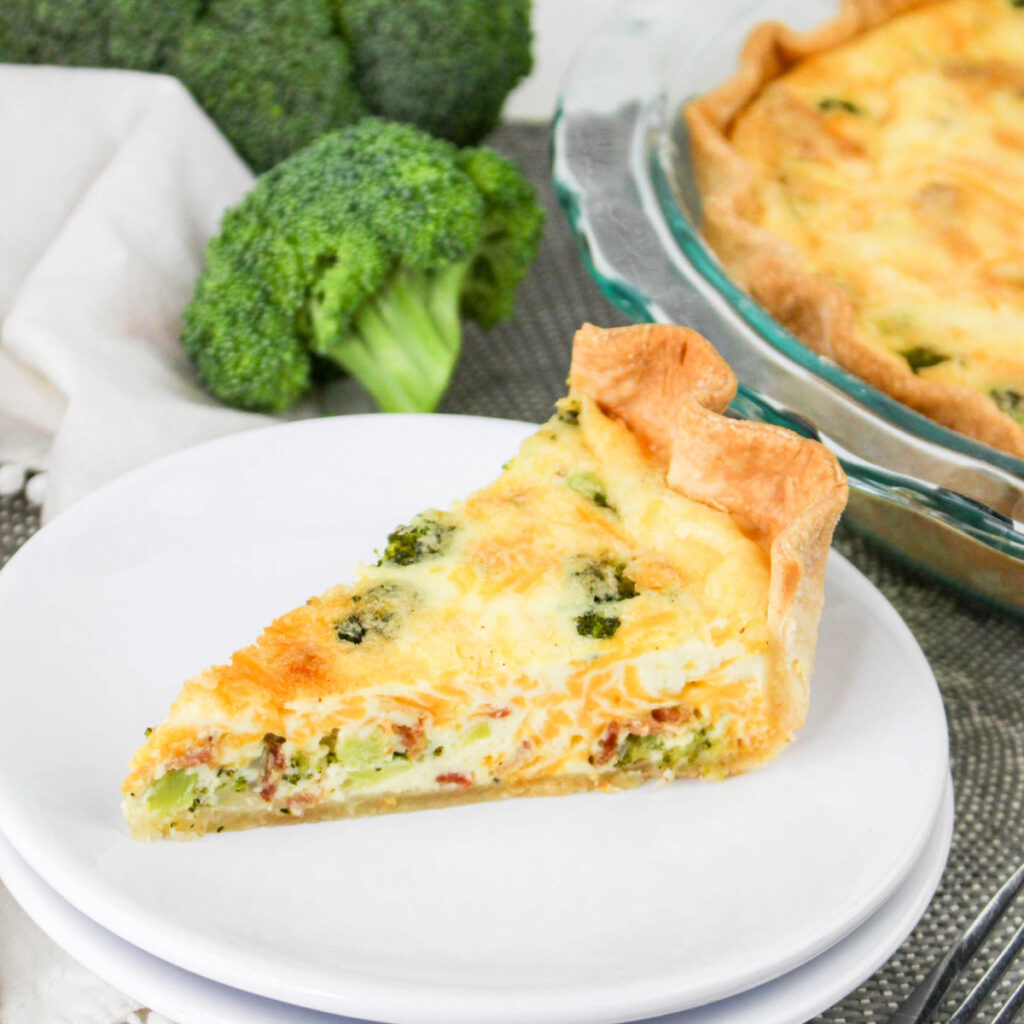 A slice of quiche on a white serving plate.